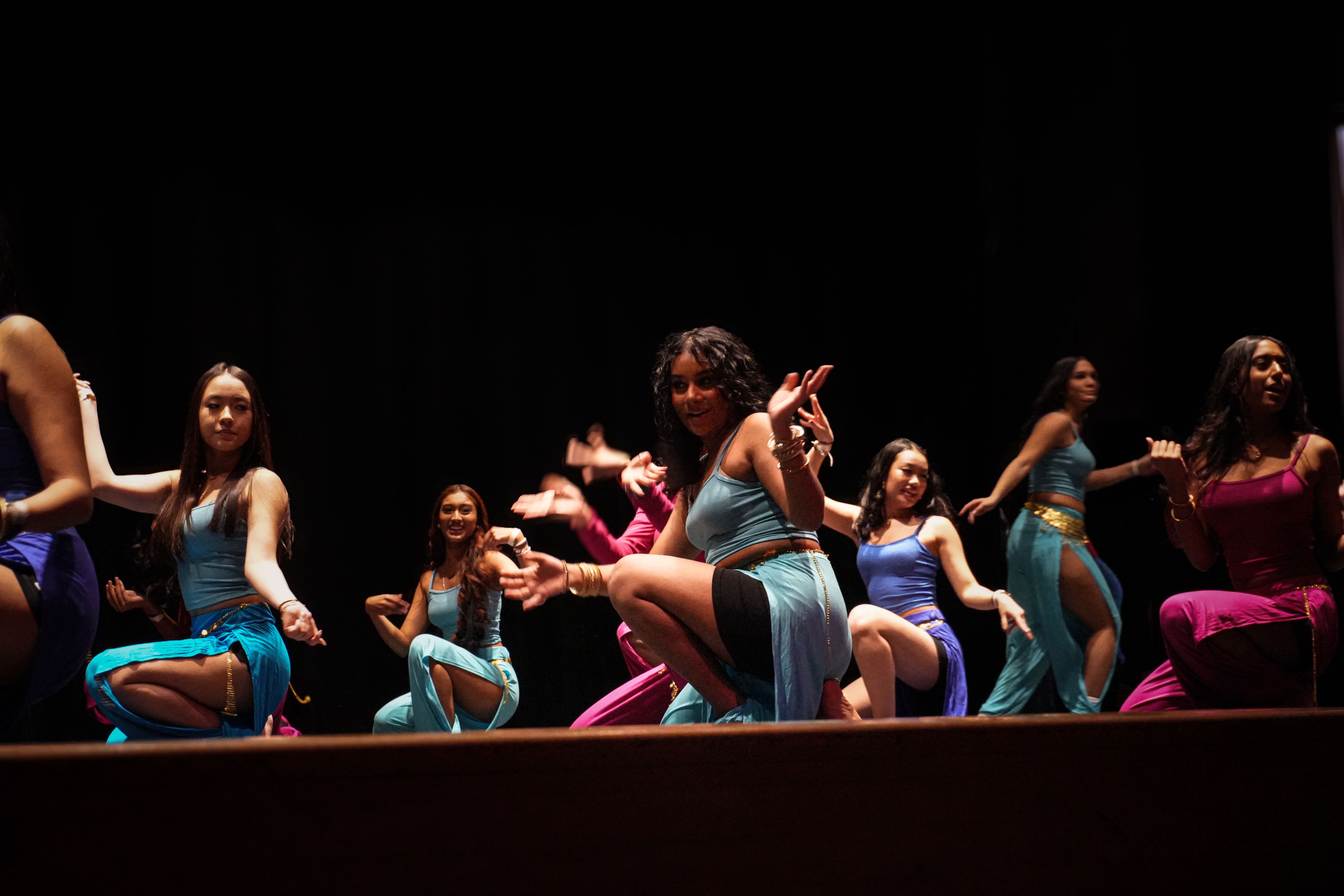 Hundreds of small orange flowers in bloom against green grass.